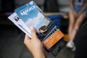 Closeup of hand holding Bangkok travel guide brochure